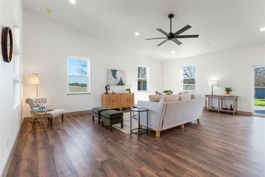 Living area with a ceiling fan, baseboards, dark wood finished floors, recessed lighting, and vaulted ceiling