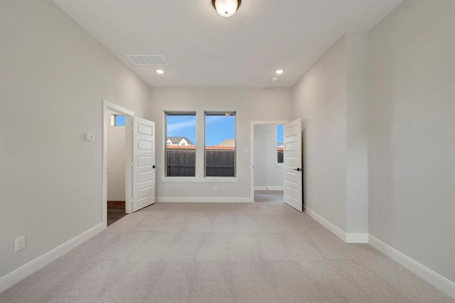 Empty room featuring light colored carpet and recessed lighting