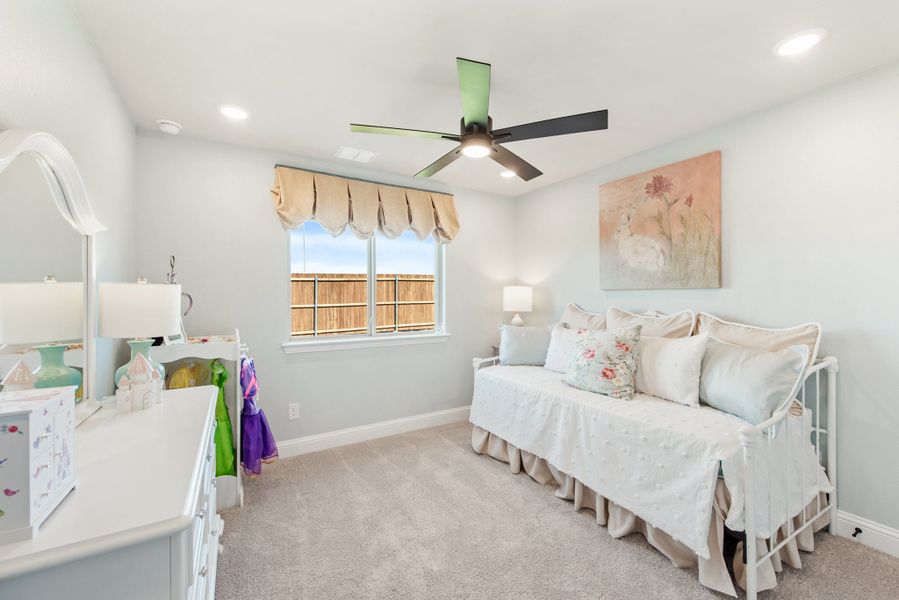 Child's bedroom with white daybed, ceiling fan, carpet floors, and white dresser with mirror
