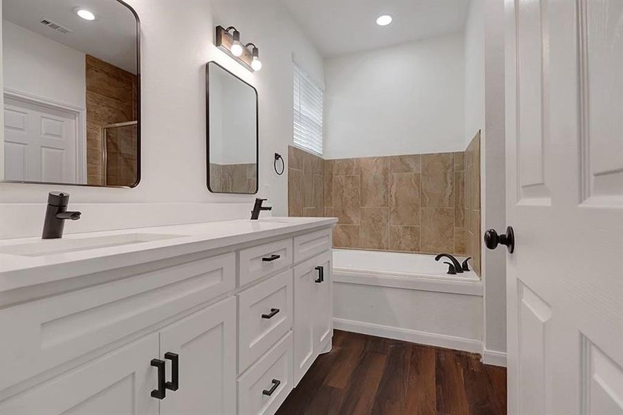 Bathroom featuring vanity, hardwood / wood-style flooring, and separate shower and tub