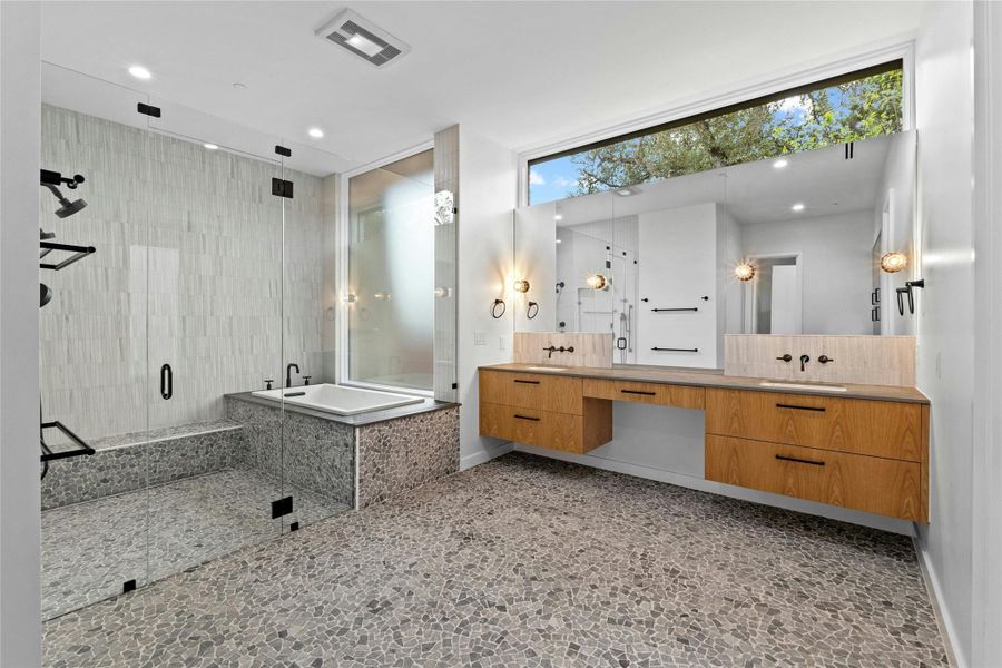 Master bath has Tumbled Pram Grey Pebbles Mosaic flooring. Tiling in the shower/bath enclosure is 2.5x10 Profound Ivory and 8x9 Pose Fino Ash Grey Combed.