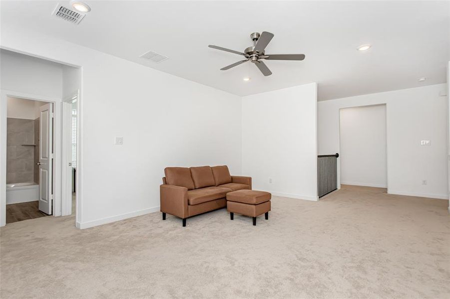 Carpeted upper-level living area featuring recessed lighting, a ceiling fan, and crisp white walls