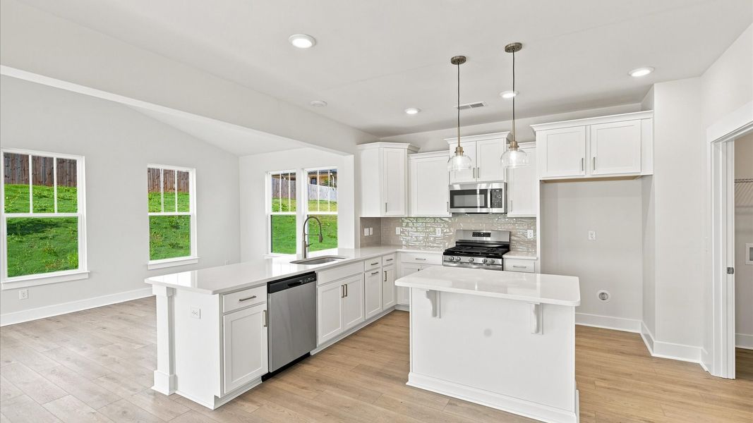 Accomplished kitchen design featuring pendant lighting above a statement island for both prep and gathering