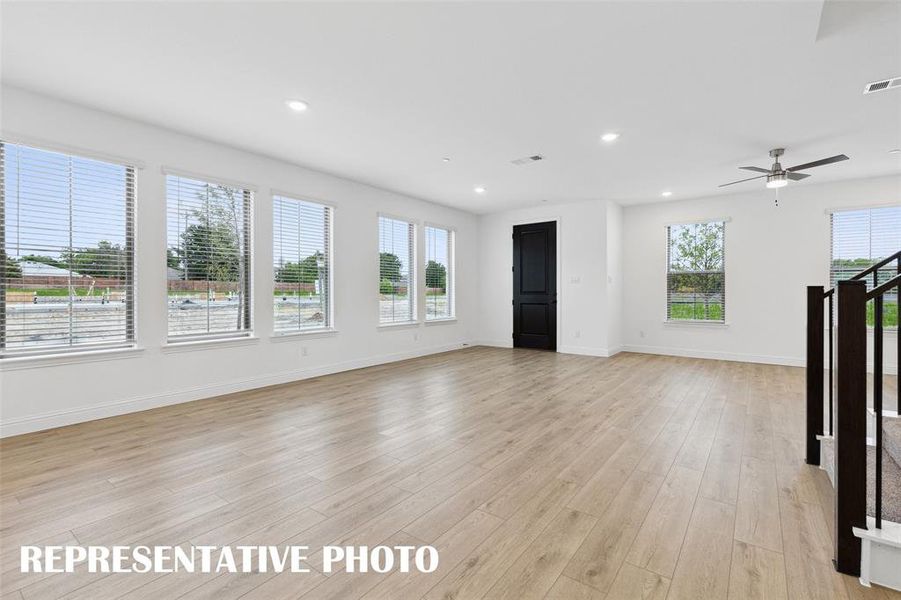 Featuring walls of windows throughout the main floor, this beautiful home is filled with natural light.  REPRESENTATIVE PHOTO