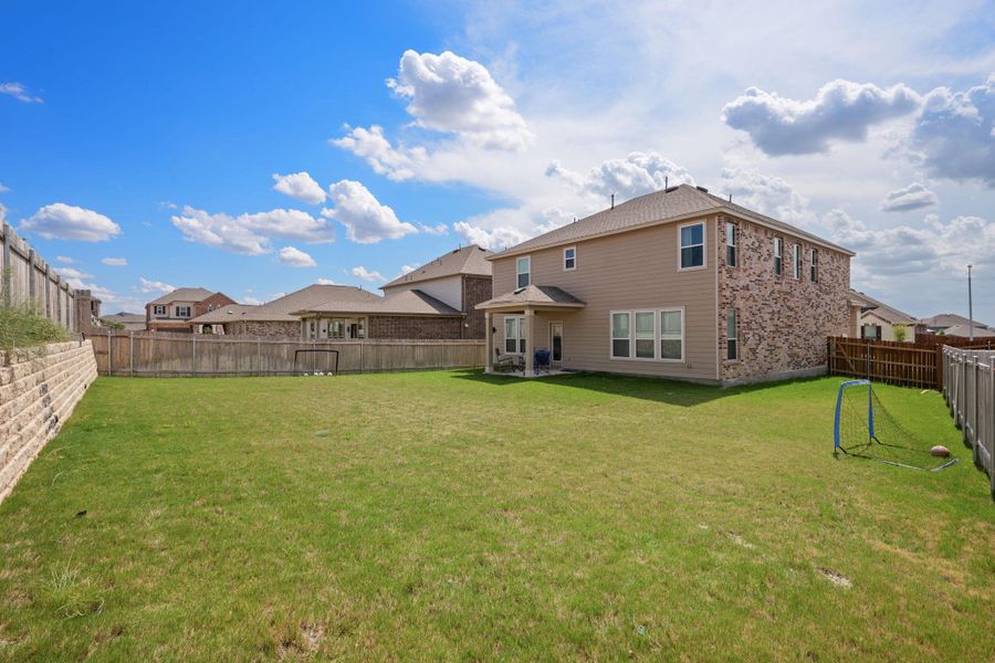 Rear view of house with a patio area and a fenced backyard