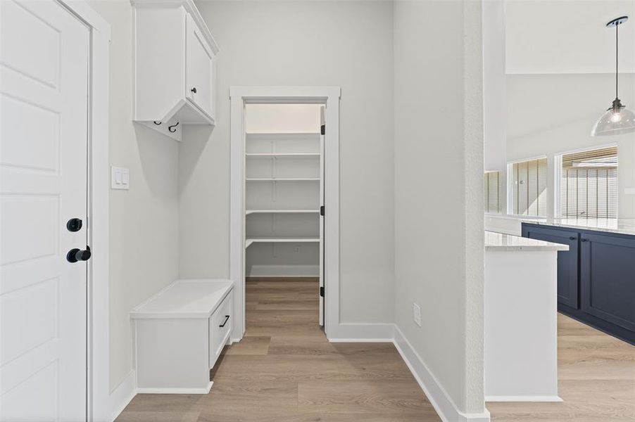 Mudroom featuring light wood-style floors and baseboards