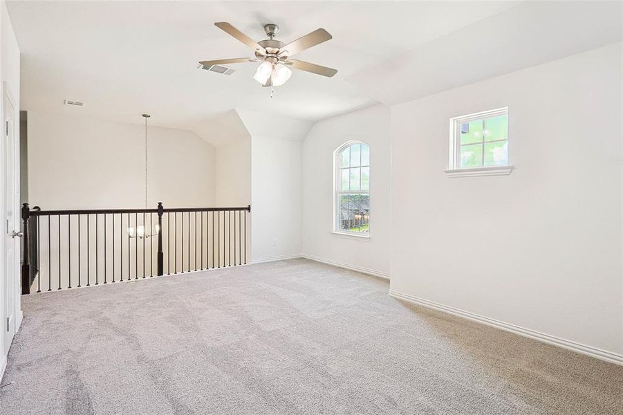 Empty room with carpet, ceiling fan, and vaulted ceiling