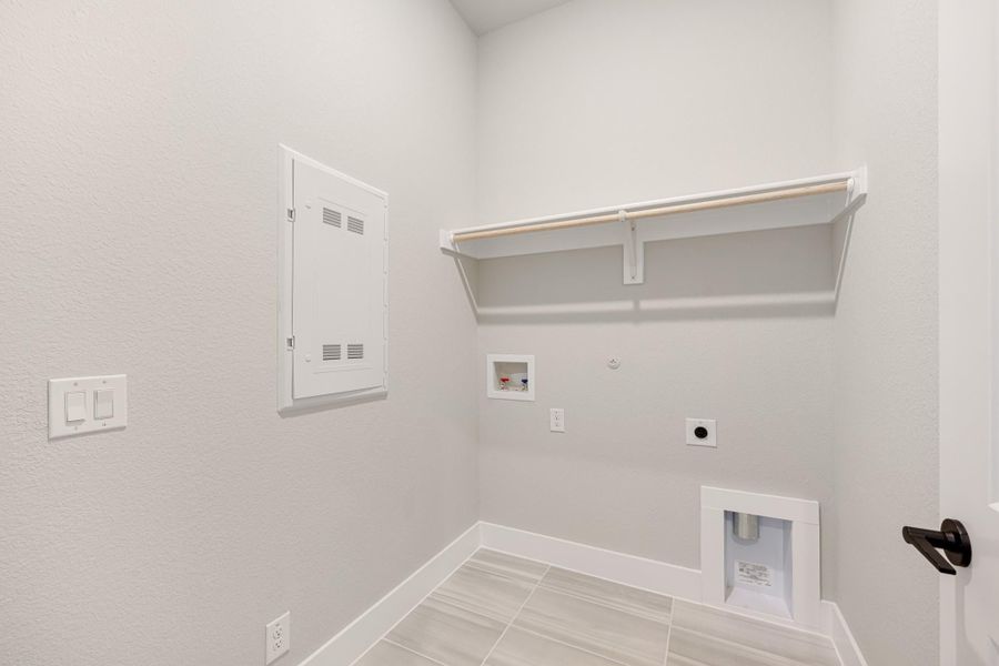 Laundry room with wall shelf, washer and dryer hookups, electrical panel, and tile floor Laundry room with wall shelf, washer and dryer hookups, electrical panel, and tile floor