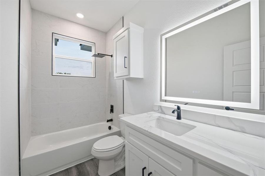 Full bathroom with shower / bathtub combination, vanity, and dark wood-style flooring