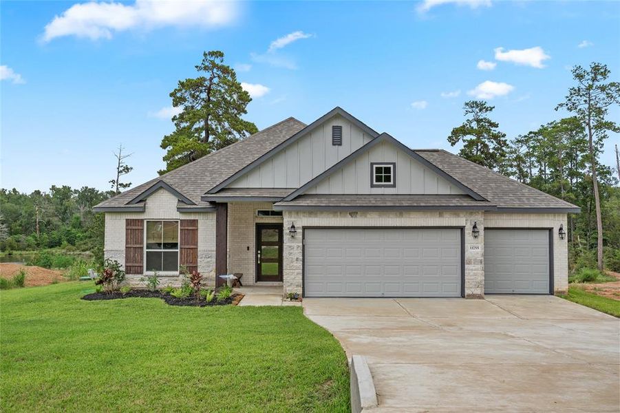 This beautiful new construction home offers a modern farmhouse exterior with a welcoming curb appeal. The stone accents and board and batten siding create a timeless aesthetic. The spacious three-car garage provides ample parking, while the well-manicured lawn and lush landscaping add to the overall charm. The home is situated on a serene lot, offering privacy and tranquility.