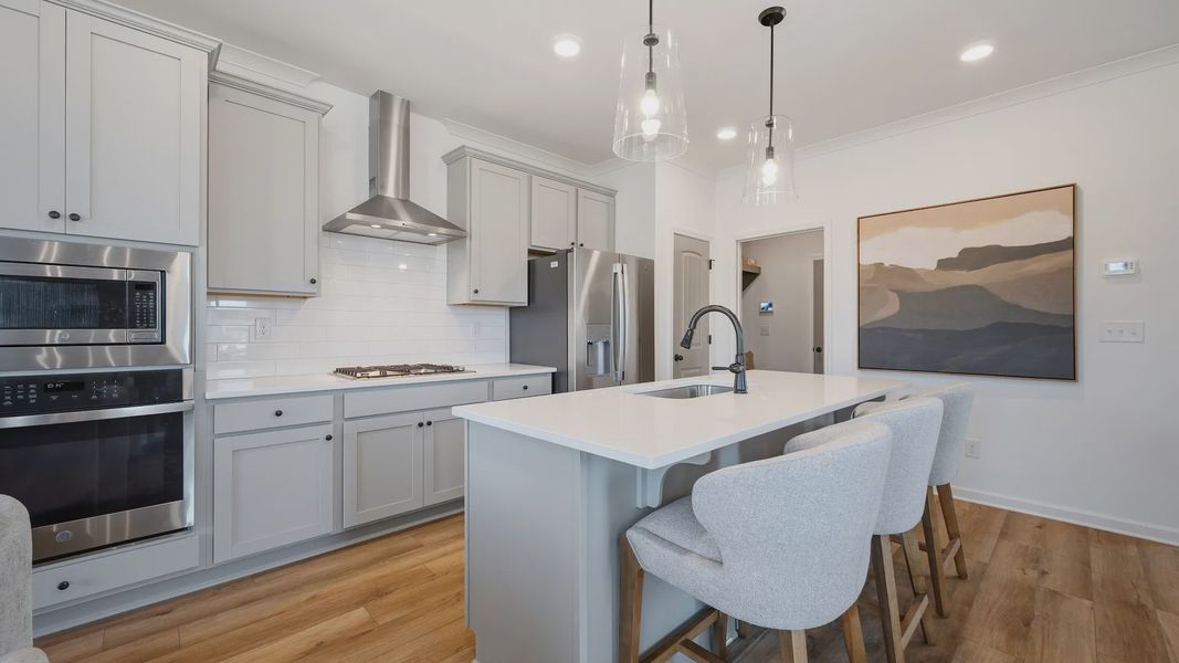 Modern kitchen with stacked microwave and oven, quartz countertops, and sleek cabinetry in townhome in Loganville, GA. Modern kitchen with stacked microwave and oven, quartz countertops, and sleek cabinetry in townhome in Loganville, GA.