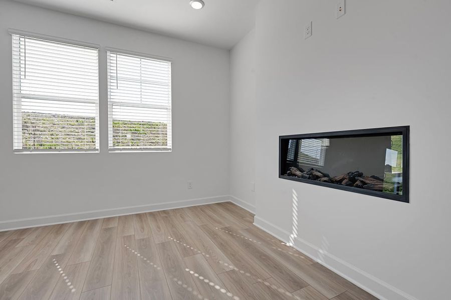 A room with a tv and a wood floor.