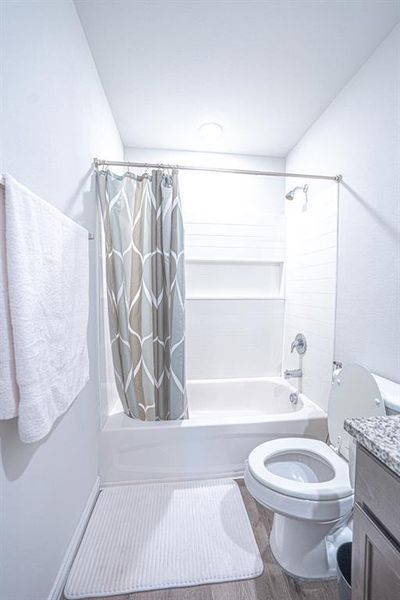 Bathroom with shower / tub combo, vanity, and wood finished floors