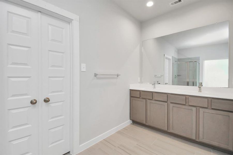 Double sinks, light colored cabinets, and modern hardware.