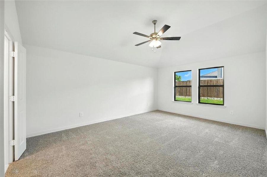 Unfurnished room featuring carpet, lofted ceiling, and ceiling fan