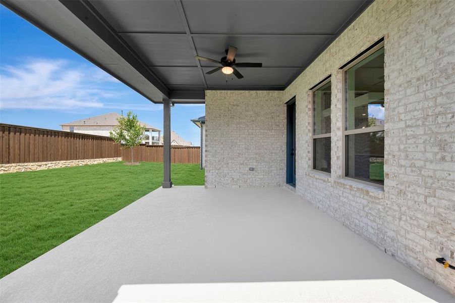 Covered patio featuring a ceiling fan and a light-colored brick exterior Covered patio featuring a ceiling fan and a light-colored brick exterior