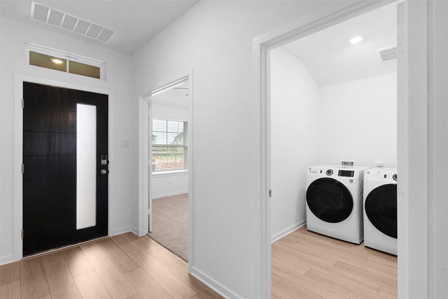 Laundry area with light wood-type flooring, washer and clothes dryer, and recessed lighting