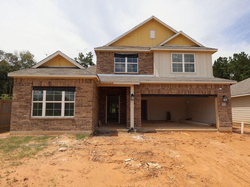 Front exterior of a new home in Pinewood at Grand Texas, New Caney, TX, highlighting curb appeal (Image 1).