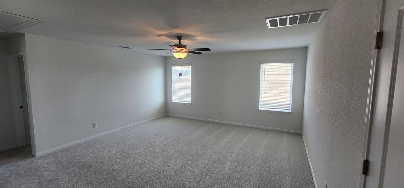A spacious room offers ample natural light and a practical ceiling fan for comfortable living. A spacious room offers ample natural light and a practical ceiling fan for comfortable living.