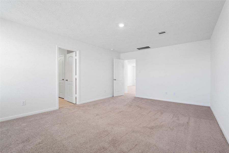 Additional view of the primary bedroom looking towards entrance to primary bathroom. Additional view of the primary bedroom looking towards entrance to primary bathroom.