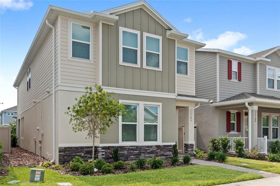 Front exterior of a new home in Harvest at Ovation, Winter Garden, FL, highlighting curb appeal (Image 24).
