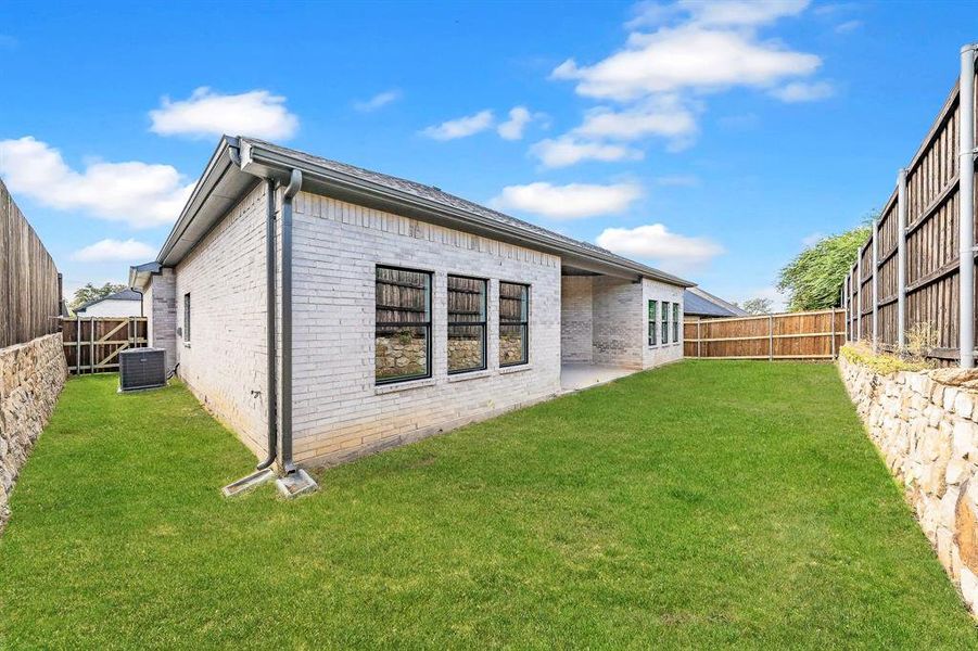 Back of property with brick siding, a patio, and a fenced backyard