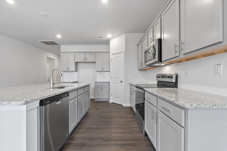 A kitchen with white cabinets.