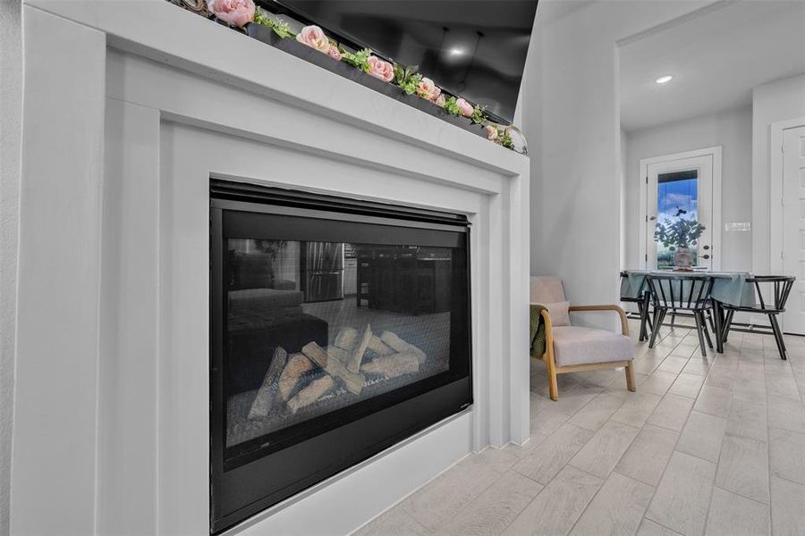 White-trimmed fireplace with a glass-front insert and log media