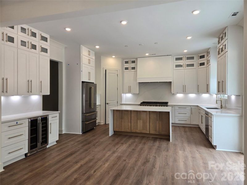 Modern kitchen featuring white soft-close cabinetry, a natural wood-tone island, and comfortable bar seating. Modern kitchen featuring white soft-close cabinetry, a natural wood-tone island, and comfortable bar seating.