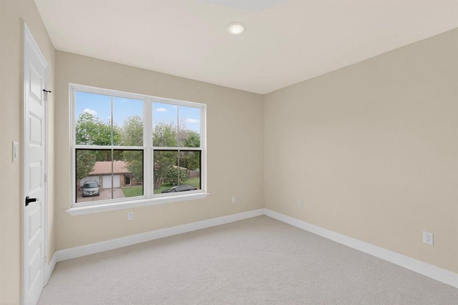 Neutral tone walls with white trim, new carpet flooring, and a large multi-pane window
