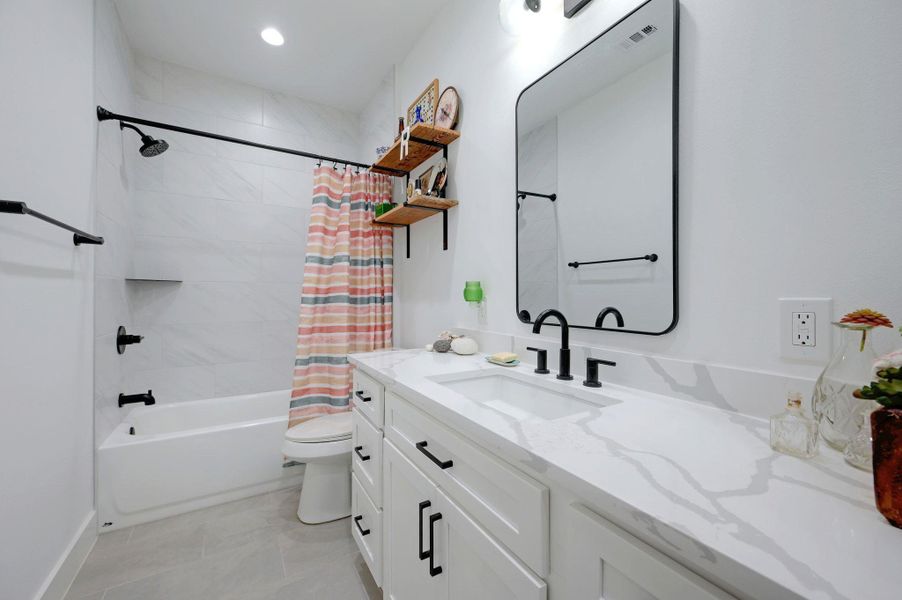 Bathroom with vanity, shower / tub combo, and recessed lighting