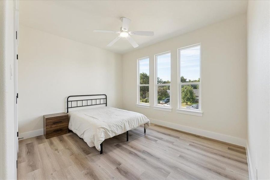 Bedroom with light wood finished floors and a ceiling fan