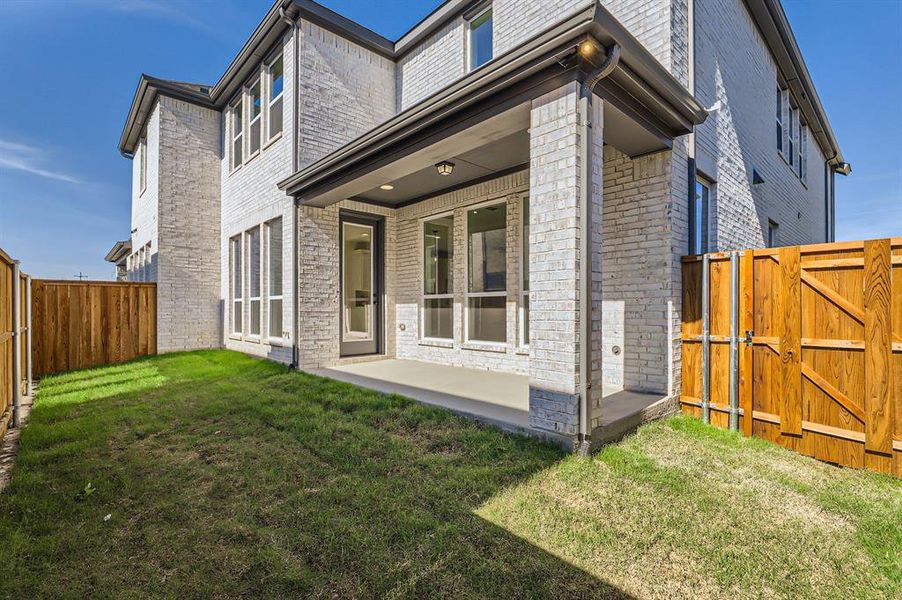 Rear view of property with a yard and a patio area