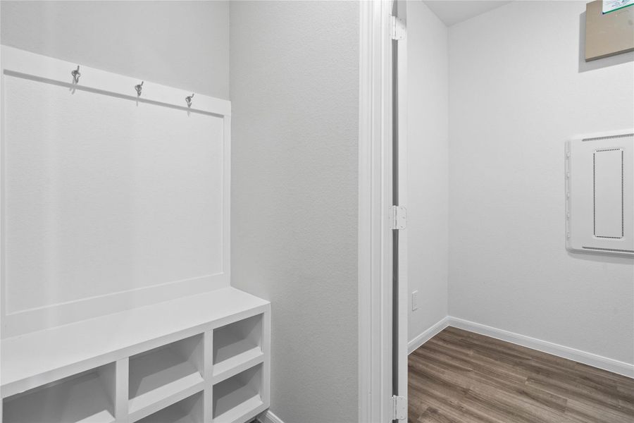 This dedicated area features a custom built-in bench with hooks, perfect for organizing coats, bags, and shoes right off the main hallway, keeping the rest of the home tidy. This dedicated area features a custom built-in bench with hooks, perfect for organizing coats, bags, and shoes right off the main hallway, keeping the rest of the home tidy.