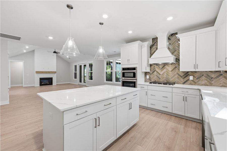 An open kitchen boasts a central island and seamle