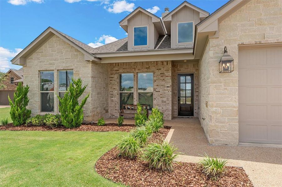 Front exterior with landscaping and covered front porch. Front exterior with landscaping and covered front porch.