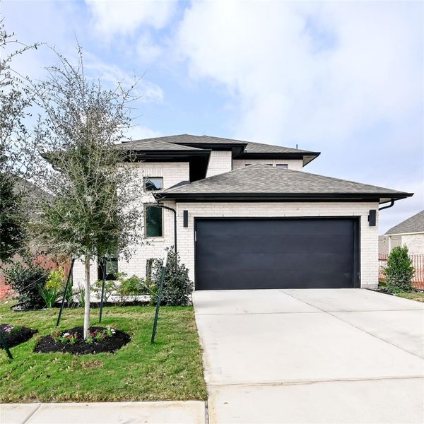 Prairie-style house featuring brick siding, an attached garage, a front yard, a shingled roof, and concrete driveway Prairie-style house featuring brick siding, an attached garage, a front yard, a shingled roof, and concrete driveway
