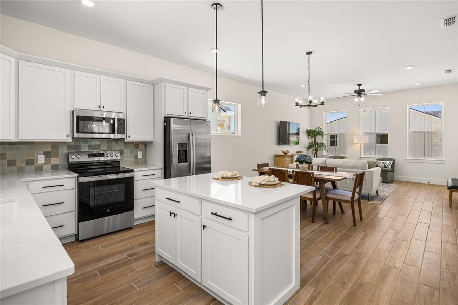 A pristine white kitchen island anchors this inviting open-concept living space with sleek stainless steel appliances.
