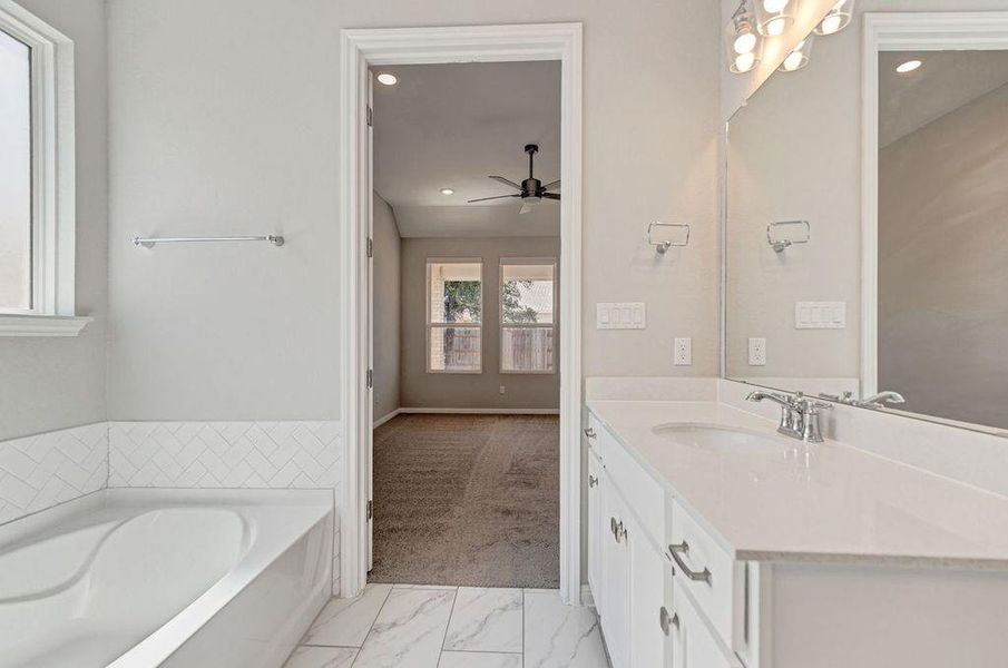 Bathroom featuring vanity, a garden tub, light marble finish flooring, recessed lighting, and ceiling fan Bathroom featuring vanity, a garden tub, light marble finish flooring, recessed lighting, and ceiling fan