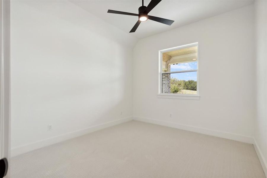 Carpeted empty room featuring ceiling fan