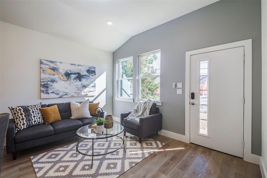 Living room with hardwood / wood-style floors and lofted ceiling