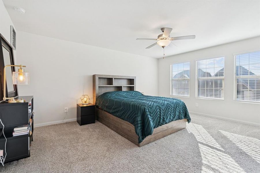 Carpeted bedroom featuring baseboards and ceiling fan