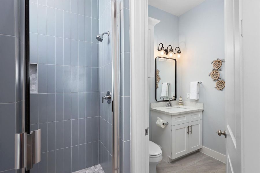 This full bath also connects to the hallway, offering easy access for guests and a sleek, functional design that maximizes use of space.