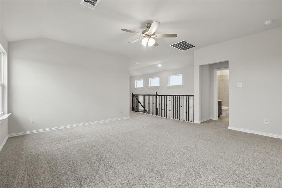 Unfurnished room with a ceiling fan, lofted ceiling, carpet flooring, and a smoke detector Unfurnished room with a ceiling fan, lofted ceiling, carpet flooring, and a smoke detector
