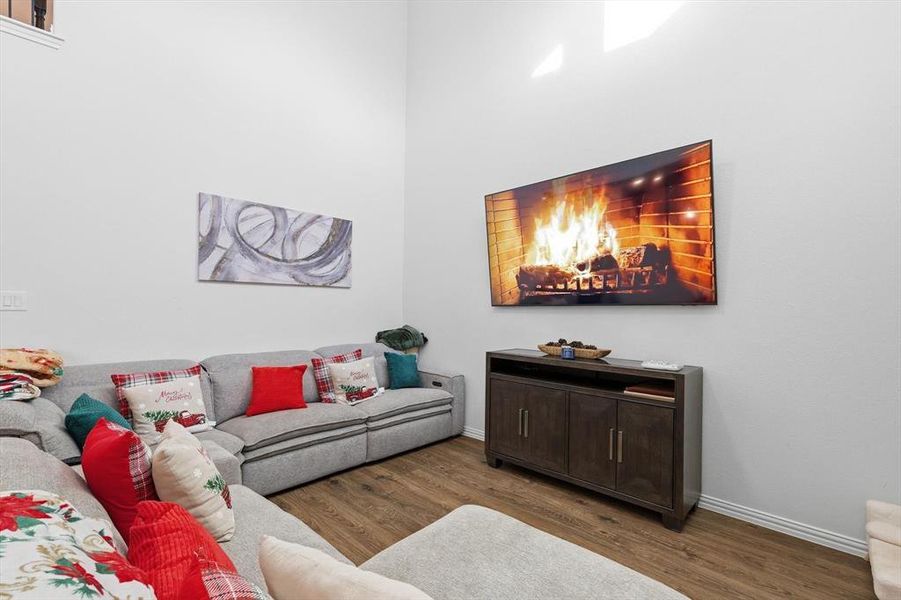 Living area featuring dark wood-style flooring and baseboards
