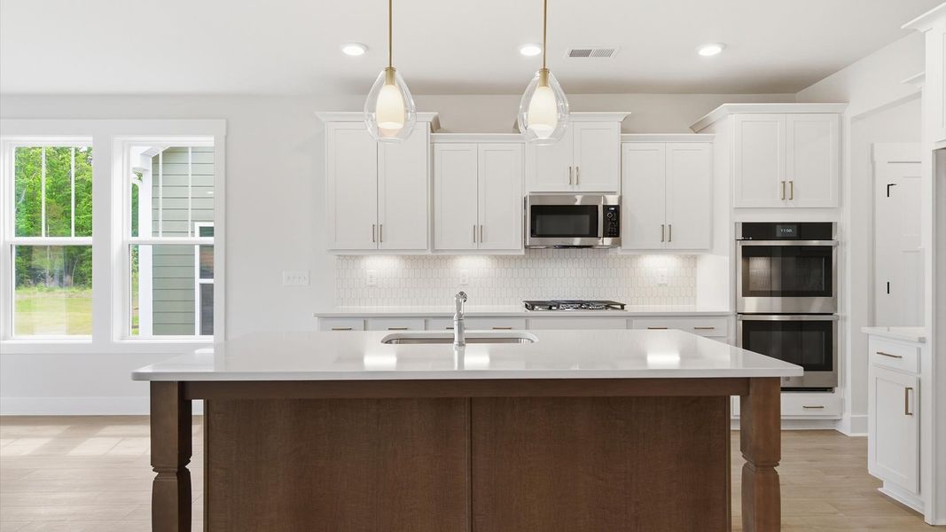 Top-notch kitchen featuring pendant lighting over a statement 9-foot island with seating located in Simpsonville, SC