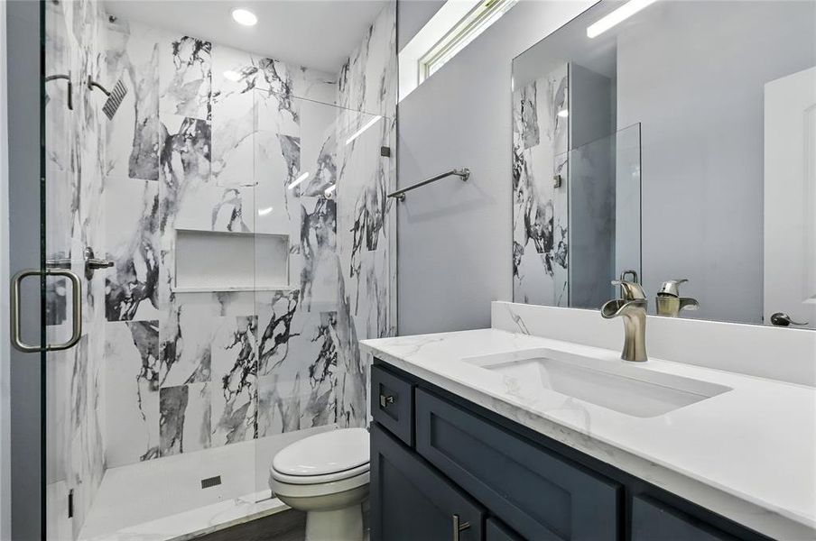 Full bath with vanity and a marble finish shower
