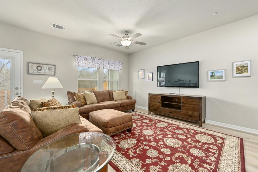 Living room with ceiling fan, plenty of natural light, and light hardwood / wood-style flooring