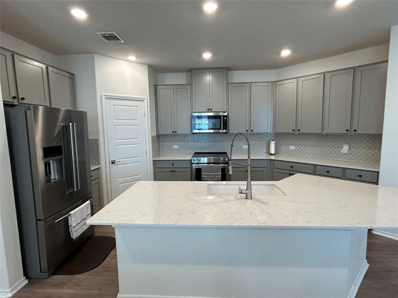 Kitchen featuring gray cabinets, stainless steel appliances, beautiful tile backsplash, light stone counters, and recessed lighting. So much prep space! Kitchen featuring gray cabinets, stainless steel appliances, beautiful tile backsplash, light stone counters, and recessed lighting. So much prep space!