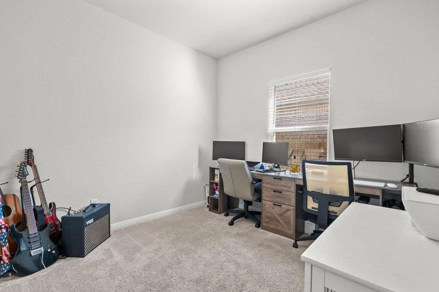 Office area featuring light carpet and baseboards